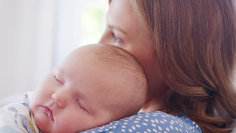 Cerca-De-Un-Tranquilo-Bebé-Durmiendo-En-El-Hombro-De-La-Madre