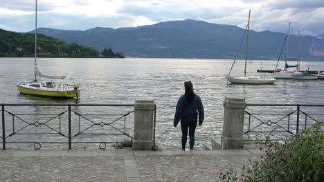 tourist visiting lakeside town of laveno-mombello in varese province, lake maggiore, lombardy, italy