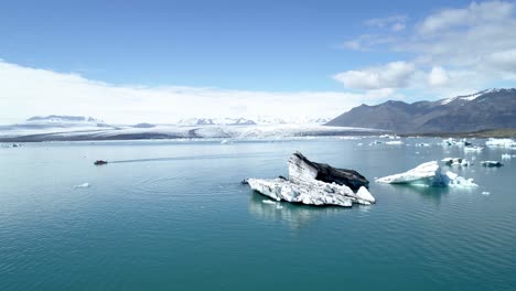 icebergs and boat on glacier lake in iceland