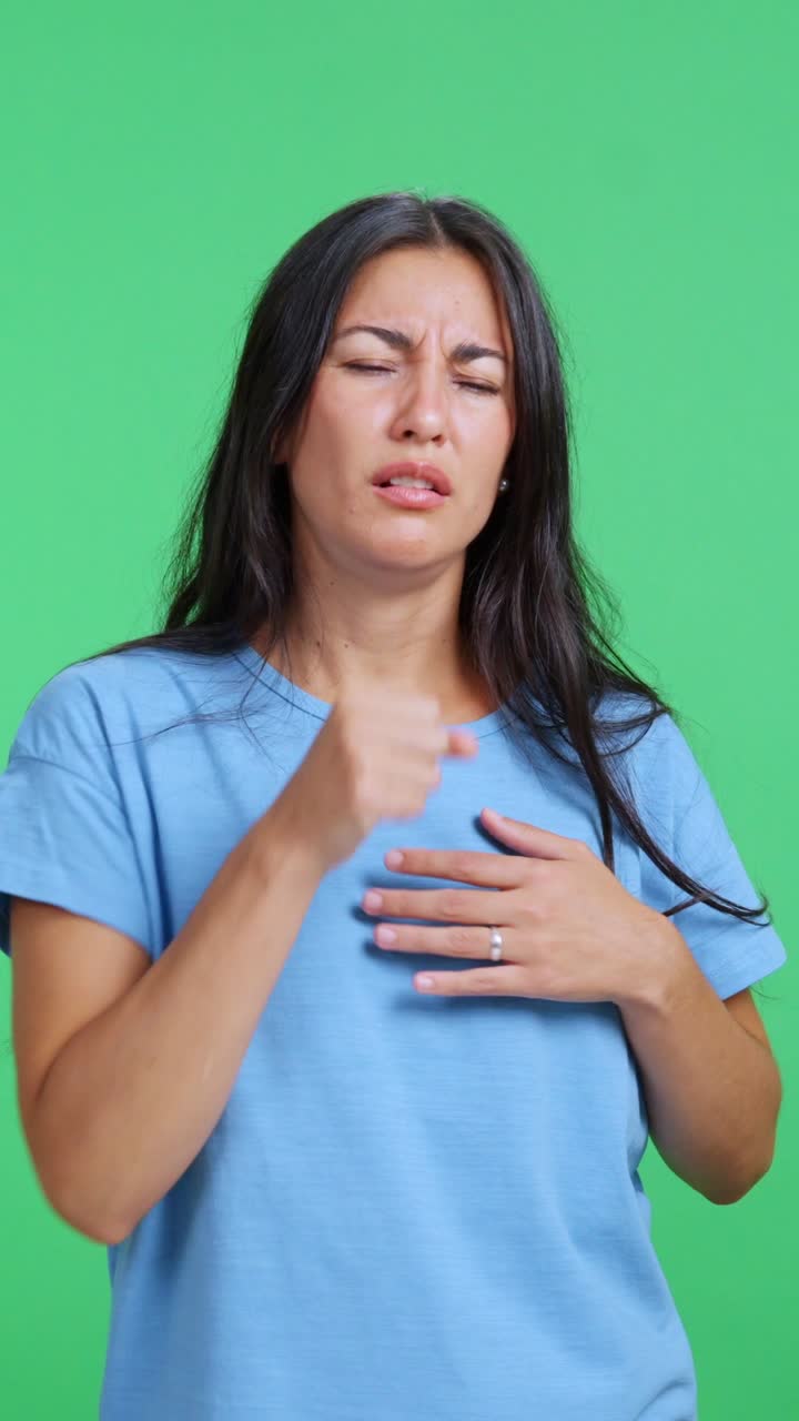Mujer con tos fuerte sintiéndose mal sobre fondo de pantalla verde