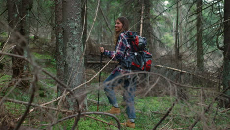 woman with backpack trekking in woods. smiling lady walking in fairytale forest