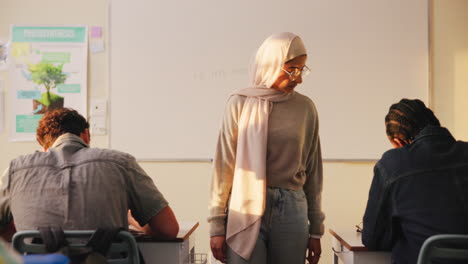 a teacher in a classroom helping students