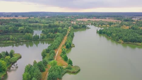 drone shot of a lake in a forest, path between lakes