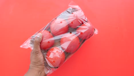 handheld package of red tomatoes