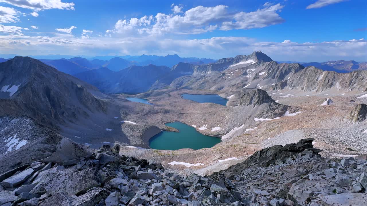 Capitol Peak Wilderness high alpine elevation Rocky Mountains Colorado aerial drone Maroon Bells Peaks Mount Snowmass 14ers Knifes Edge Ridge Pierre Lakes summer early morning blue sky cloudy left pan