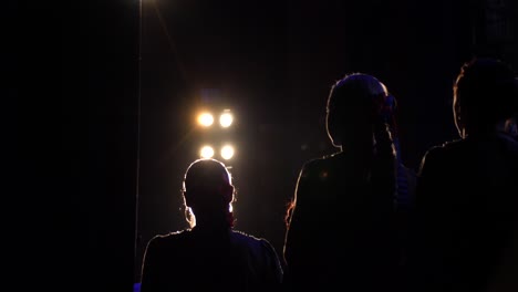 silhouette of choir members under stage lights