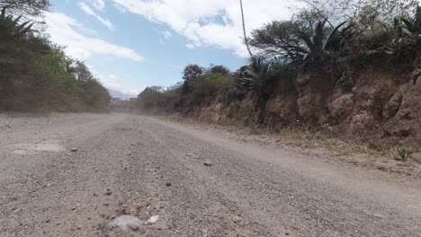 Motorcycle-riding-by-on-a-dirt-road-in-Ecuador,-South-America