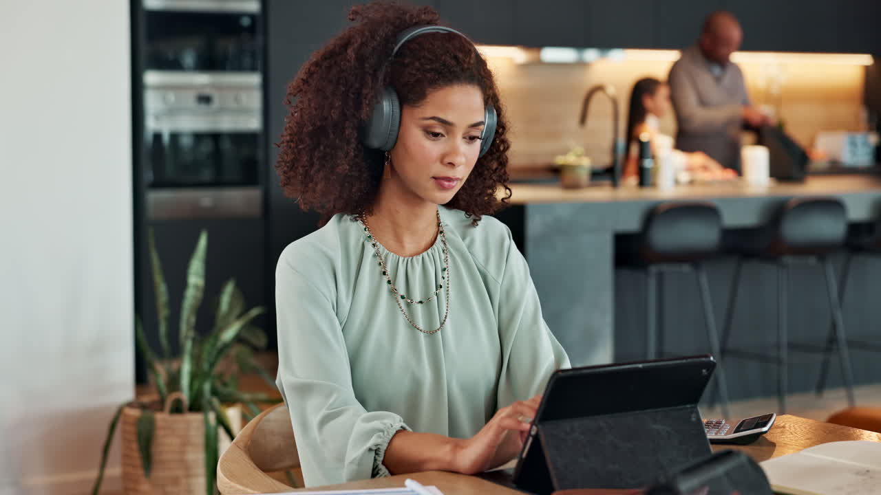 Woman working at home with family in the background