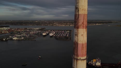 Aerial-View-Of-Dublin-Port-In-Dublin-Ireland-On-A-Cloudy-Day-With-Poolbeg-Chimney-Reveal---drone-pullback