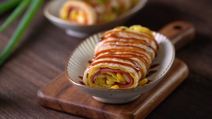 Pouring thick soy sauce over Taiwanese omelette, egg pancake roll.