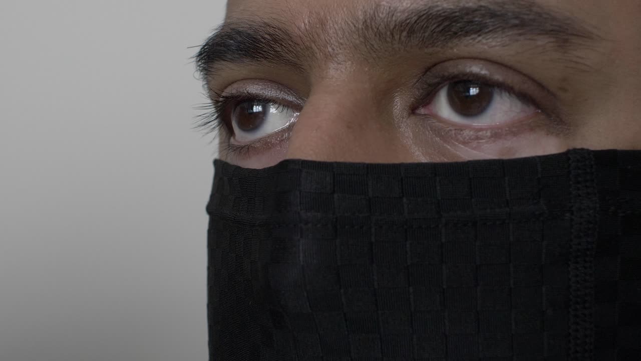 Hombre asiático británico adulto usando pasamontañas en interiores