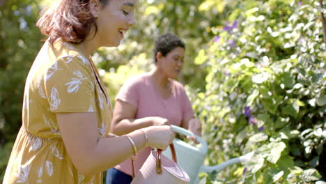 watering plants in garden, two women enjoying gardening together outdoors