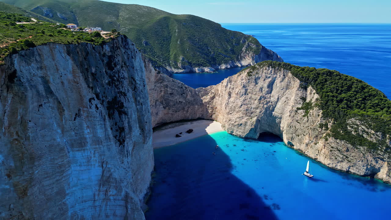 그리스의 나바기오 해변의 드론 촬영은 은 여름날에 세일링 보트와 함께