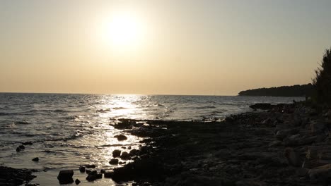 sunset time-laps of the beach near novi grad croatia with people on the shore and sun going behind clouds with visible ships and yacht