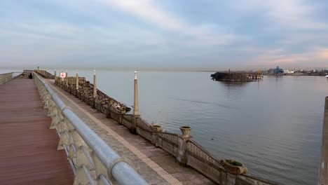 wooden-promenade-cobblestone-walkway-path-road-at-the-edge-of-the-beach-stone-coast-seaside-landscape-port-harbor-in-anzali-in-sea-landscape-the-silo-grain-industry-concept-of-middle-east-shipping