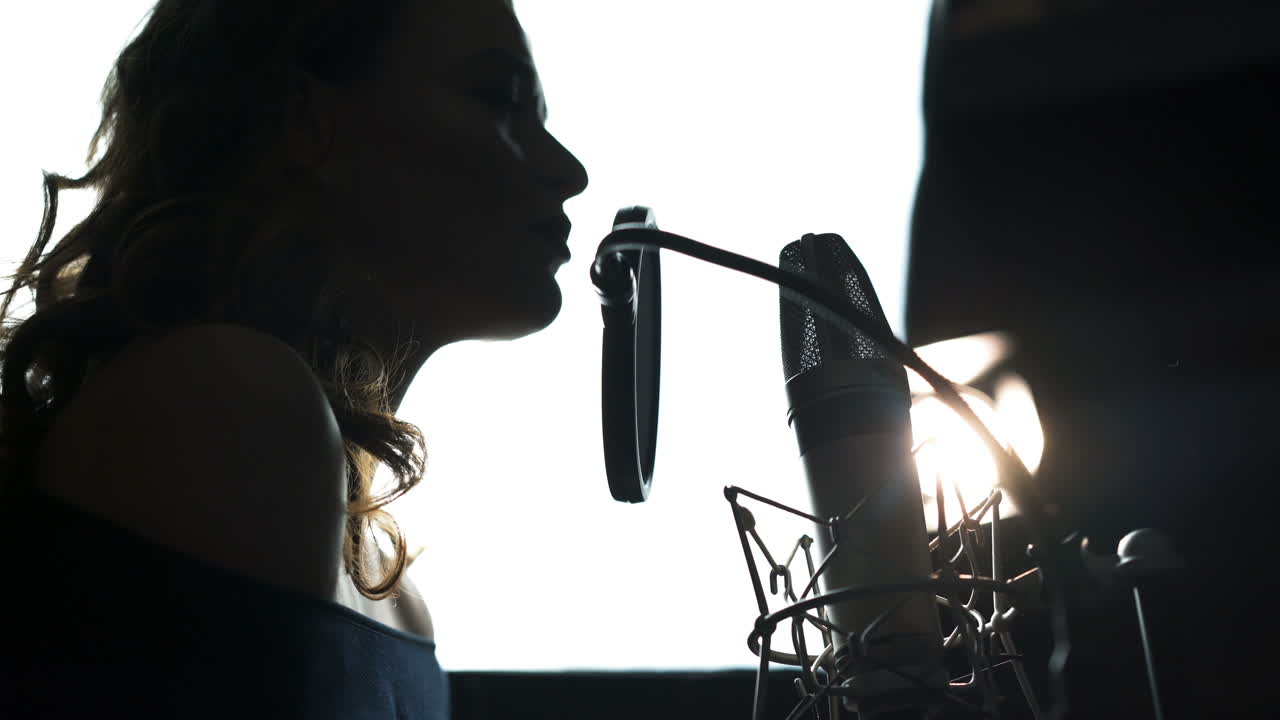 Beauty Woman with Microphone. Professional recording studio. Close-up face. Black and White