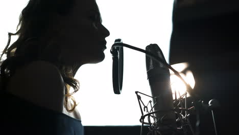 beauty woman with microphone. professional recording studio. close-up face. black and white