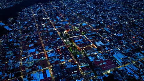 high altitude drone orbit of uruapan, michoacán at dusk or early night