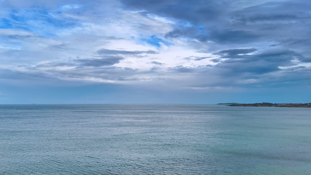 Orizzonte marino grandangolare sotto un cielo blu nuvoloso. Paesaggio marino con acqua blu calma e dense nuvole grigie sopra la linea dell'orizzonte