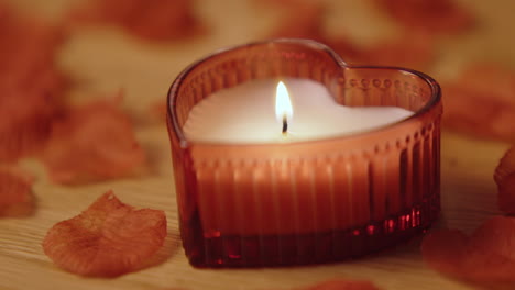 heart-shaped candle with rose petals