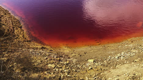 toxic red waters of lagoon in wheal maid , former mine in cornwall, england