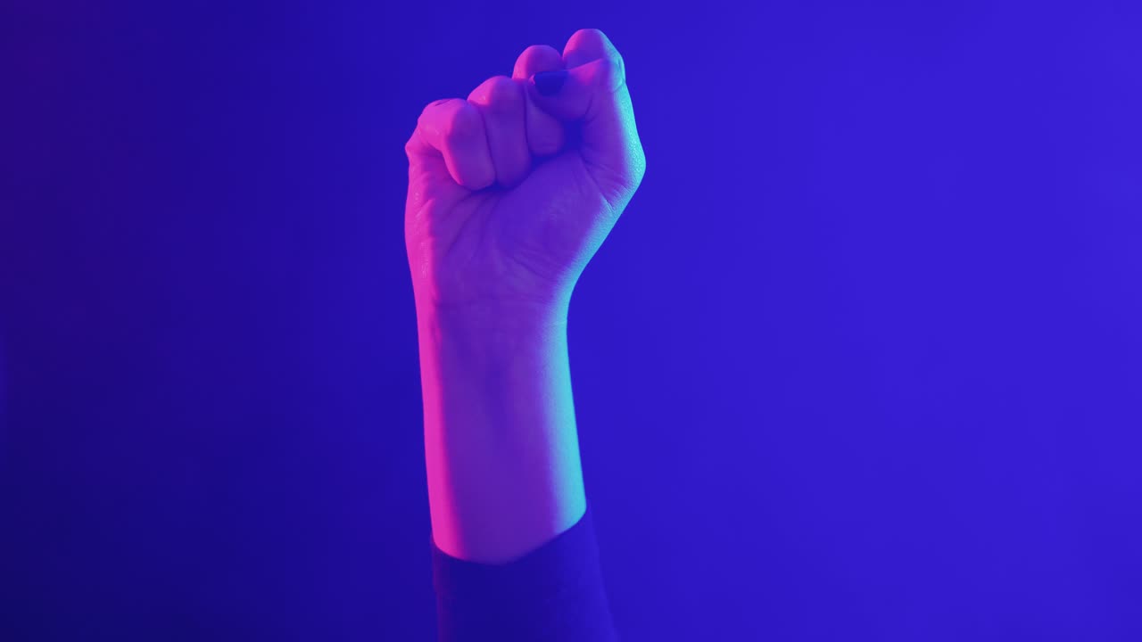 Raised Fist Symbolizing Power and Protest in Neon Light