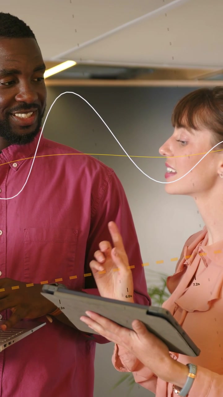 Video verticale: Donna che indica un tablet, uomo che digita su un laptop, team che lavora su dati aziendali, linee di movimento