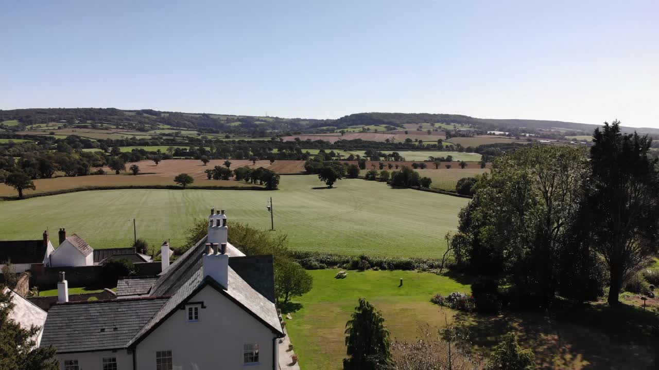 아름다운 여름날 마을과 데본 시골 위로 공중으로 떠오르는 총격