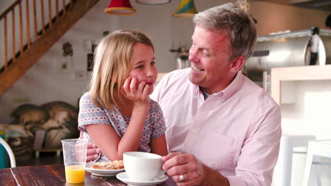 Padre-Sentado-Con-Su-Hija-En-Una-Mesa-En-Un-Café