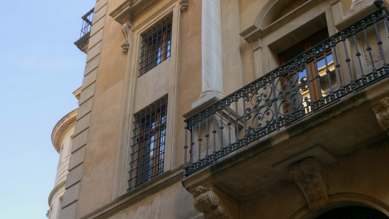 Sunlit Historic Building Facade Closeup, Ornate Balcony With Wrought Iron Balustrade, Tall Stone Column