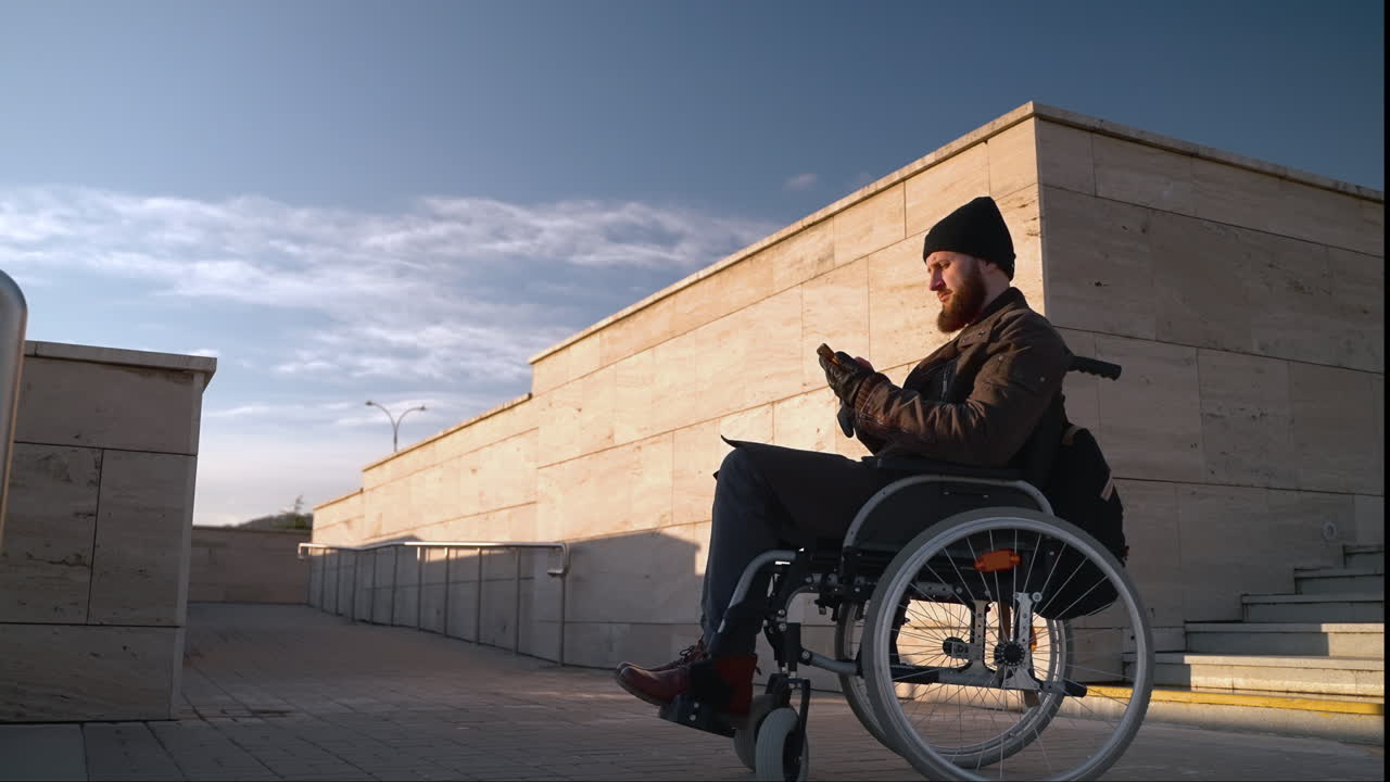 hombre en silla de ruedas usando un teléfono inteligente