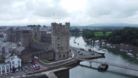 ancient caernarfon castle welsh harbour town aerial view medieval waterfront landmark wide orbit right