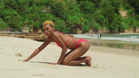 a black girl in a vibrant red bikini adds a touch of elegance to a tropical white sand beach in the caribbean kneel in the sand