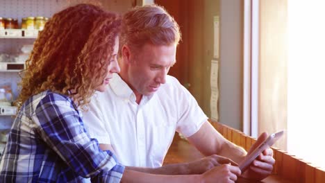 pareja usando una tableta digital en una cafetería