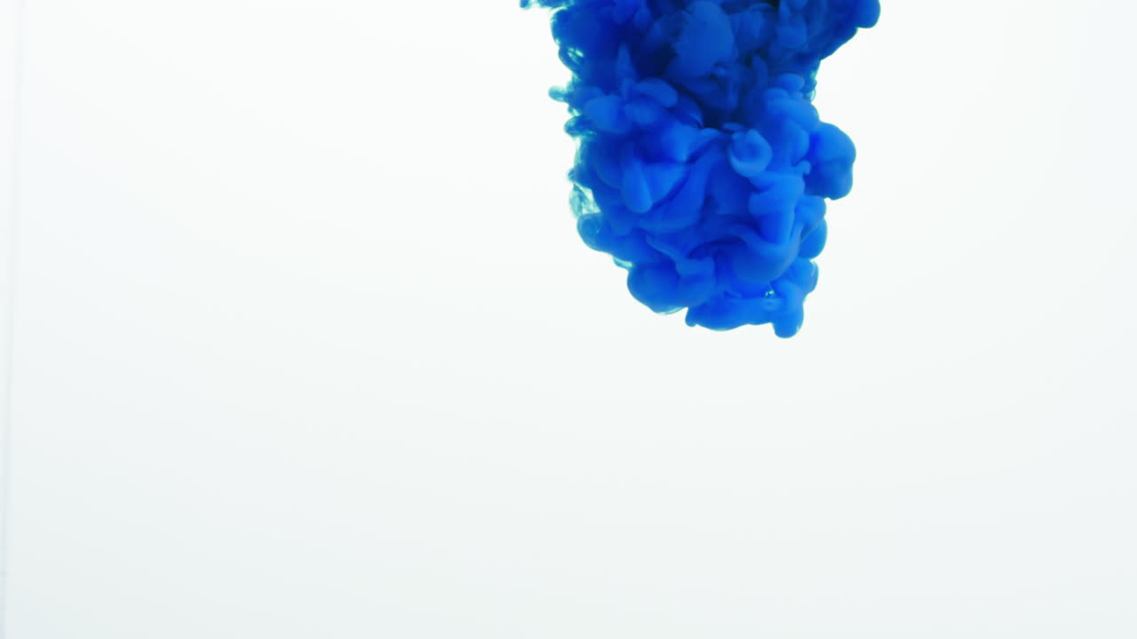 Blue Paint Or Dye Dropped Into Water Against White Background To Create Swirling Colourful Smoke Background 1