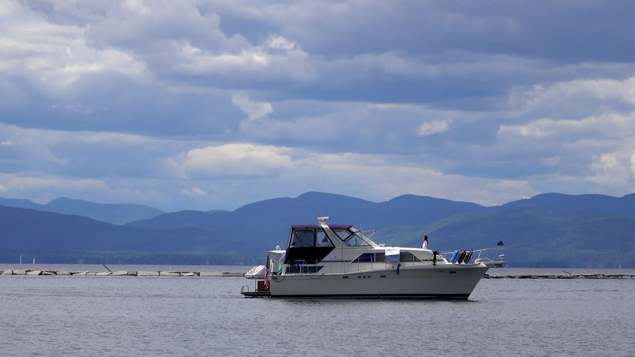 배경 에 산 들 이 있는  ⁇ 플레인 호수 에 있는 캐빈 크루저 보트