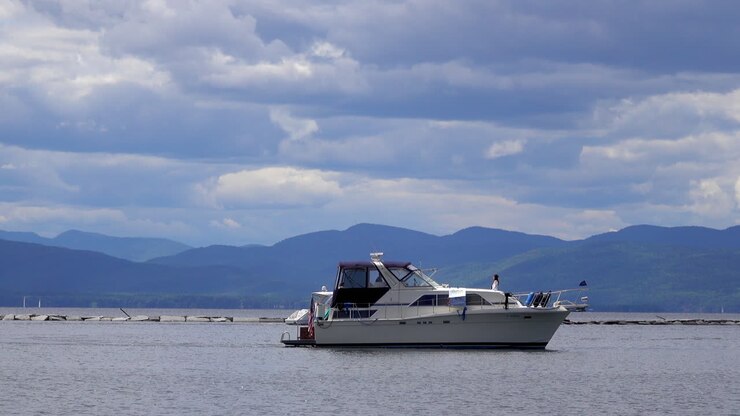 un barco crucero de cabina en el lago champlain con montañas en el fondo