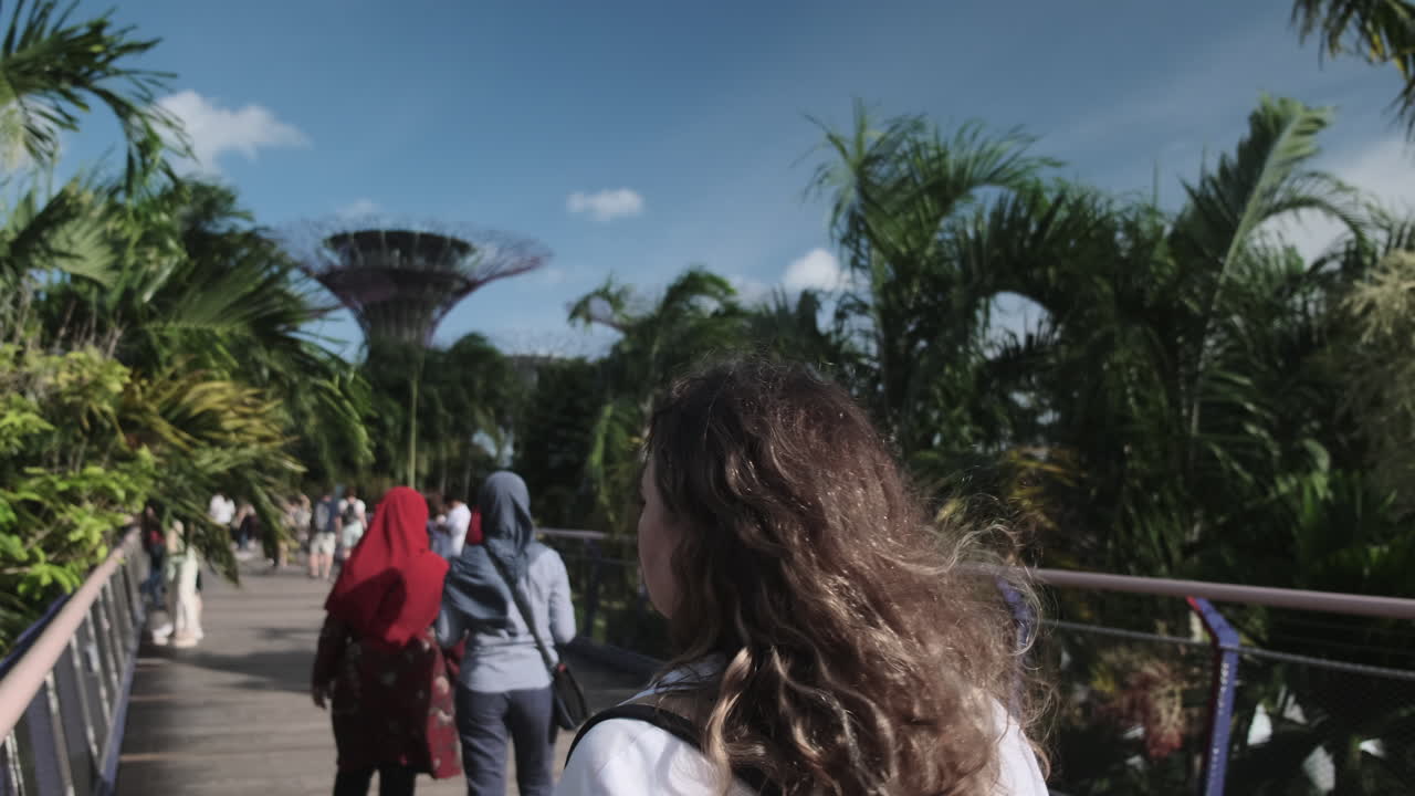 Woman Walking Through Singapore's Gardens By The Supertree Grove