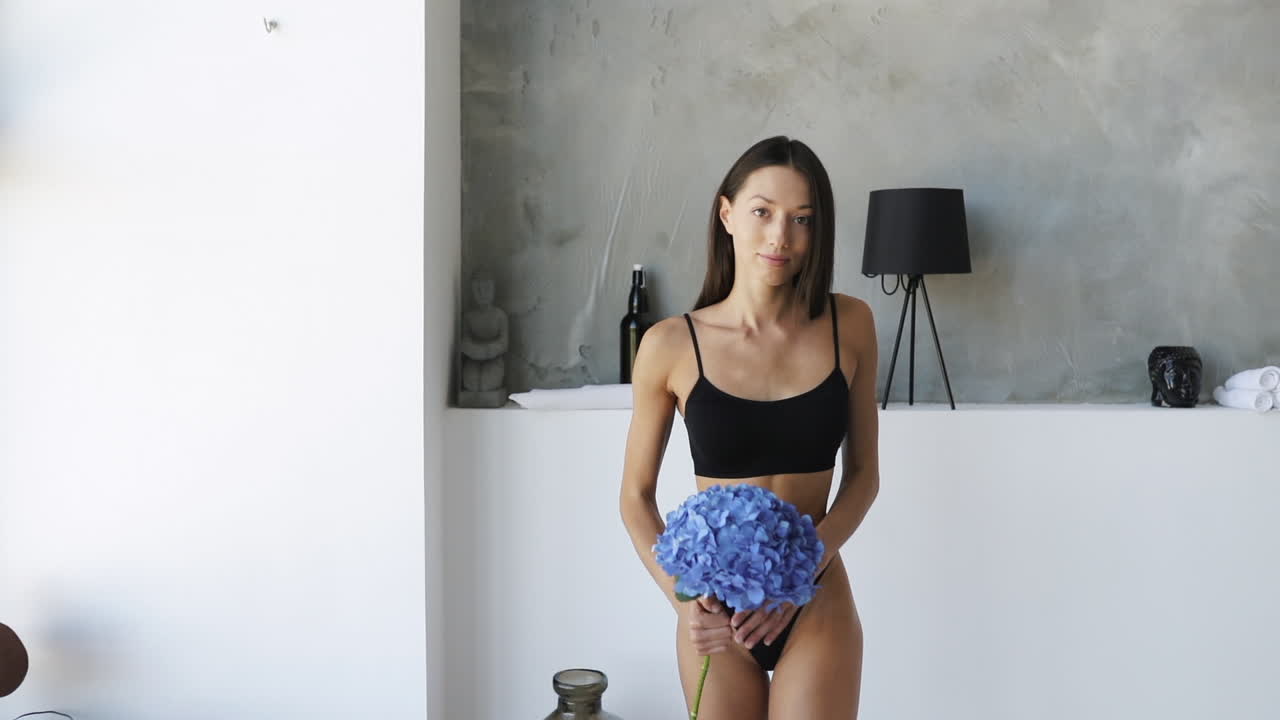 mujer en lencería negra con hortensia azul