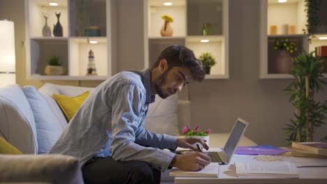 hombre feliz usando una computadora portátil por la noche.