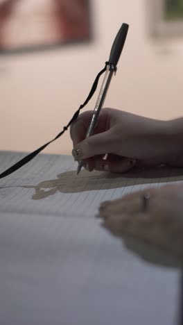 close-up of woman writing on registration list to control entry to social event