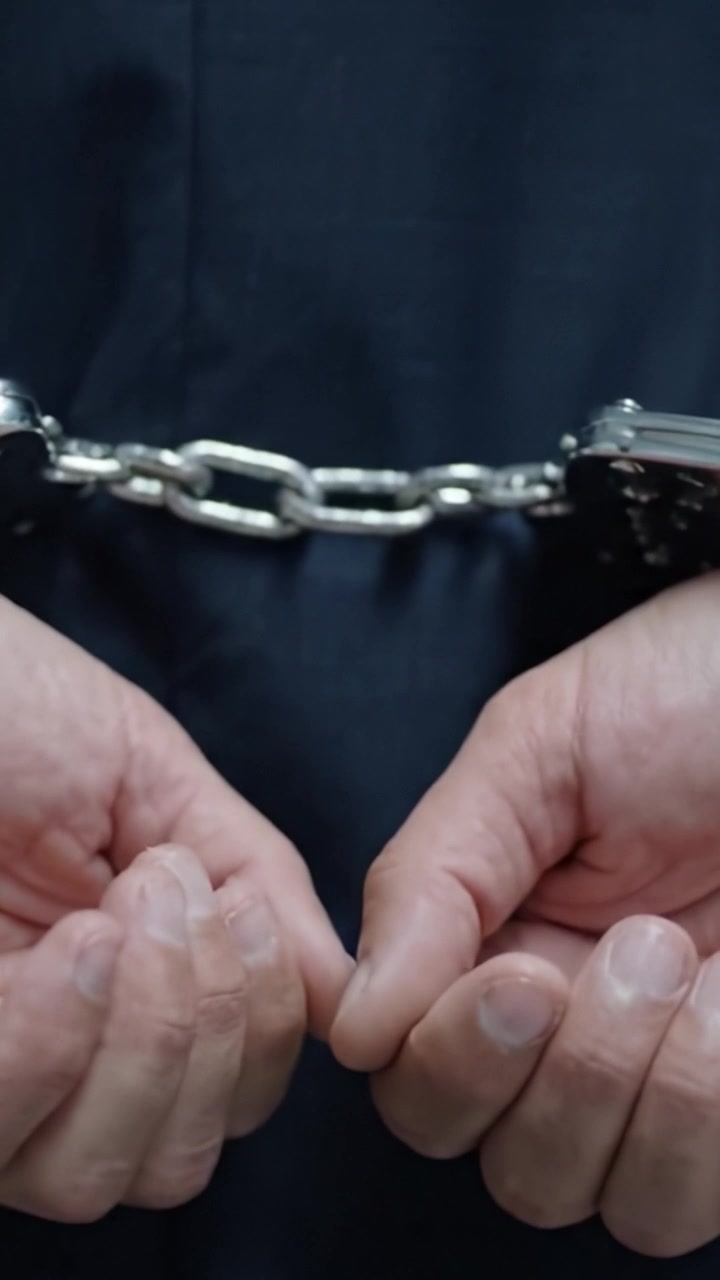 La Tensione della Restrizione: Una Narrazione Visiva che Esplora la Cattività e la Libertà Attraverso il Contrasto tra Tessuto Scuro e Manette d'Acciaio