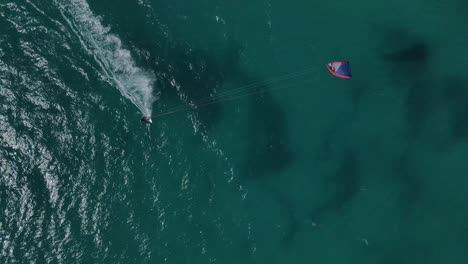 Aerial-flyover-crystal-clear-ocean-with-kite-surfer-having-fun-during-windy-and-sunny-day-in-Australia-in-Top-view