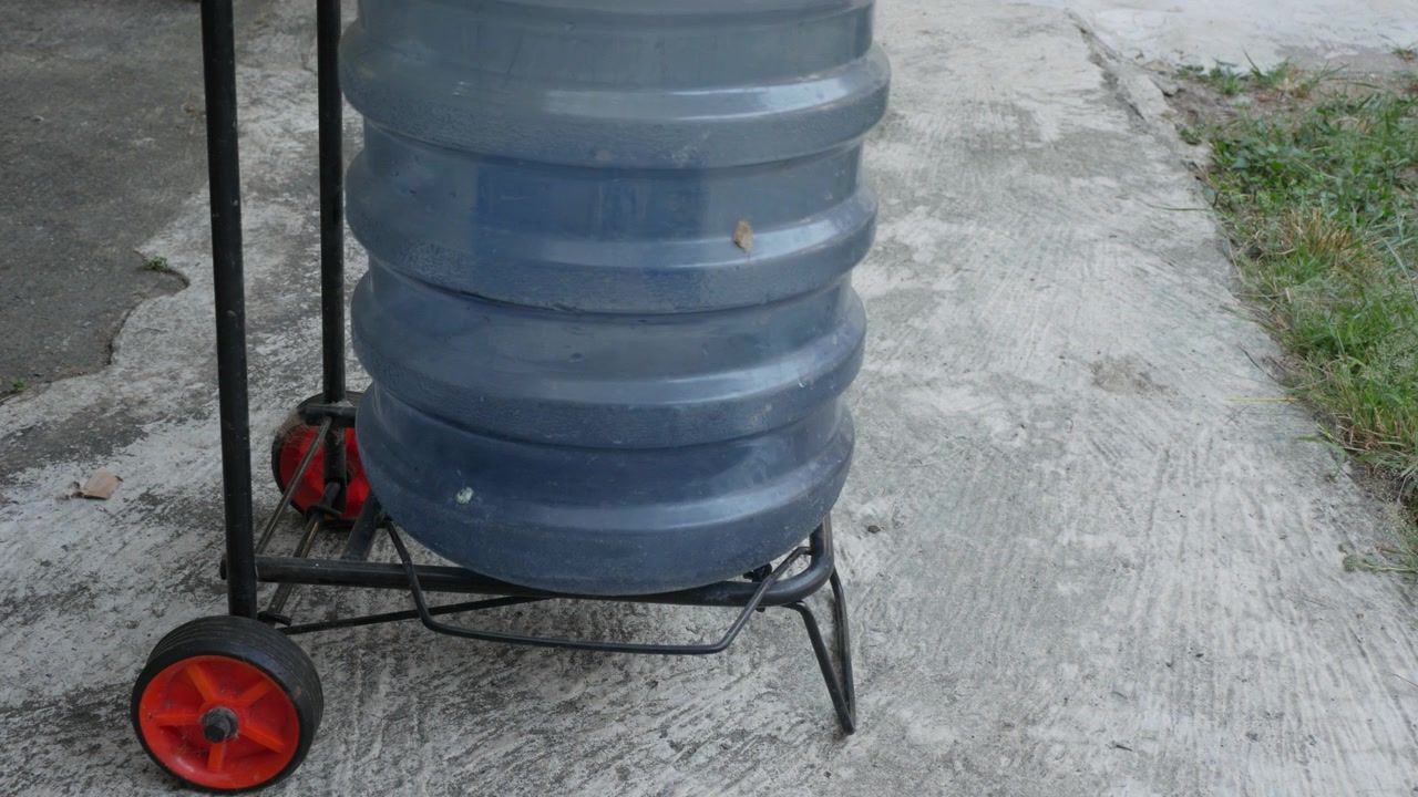 Colocando um Garrafão de Água Grande em um Carrinho de Duas Rodas.