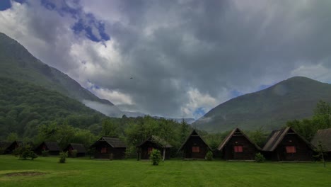 experience the rustic charm of kamp ivona tara, nestled amidst majestic mountains. traditional wooden cabins offer a peaceful retreat in this stunning natural landscape, under a dramatic sky.