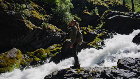 woman hiking through a mountain waterfall