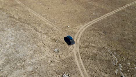 Truck-driving-along-a-dry,-dusty-dirt-road-during-a-drought---rancher-looking-for-lost-cattle