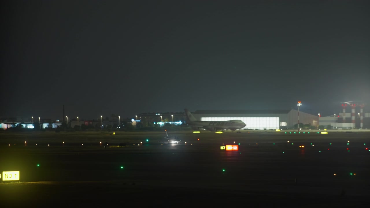 Aereo in rullaggio sulla pista dell'aeroporto di notte