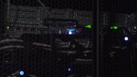 blinking green lights on computer servers in a dark room - close up