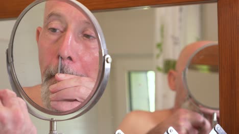 mam caucásica se corta el pelo nasal con tijeras en un baño